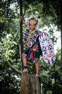 Rear view of woman standing against trees