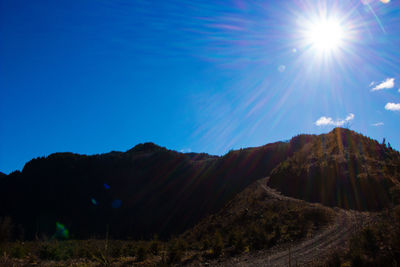 Scenic view of mountains against clear sky on sunny day