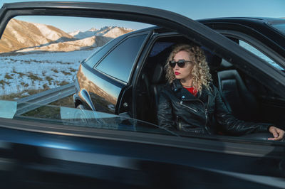 Young woman sitting in car