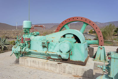 Old rusty wheel against clear blue sky