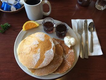 High angle view of pancakes by syrup in plate on table