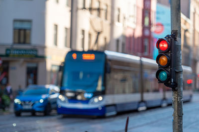 Blurred view of city traffic with traffic lights, in the foreground a semaphore with a red light