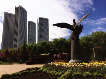 Low angle view of statue in front of park against sky