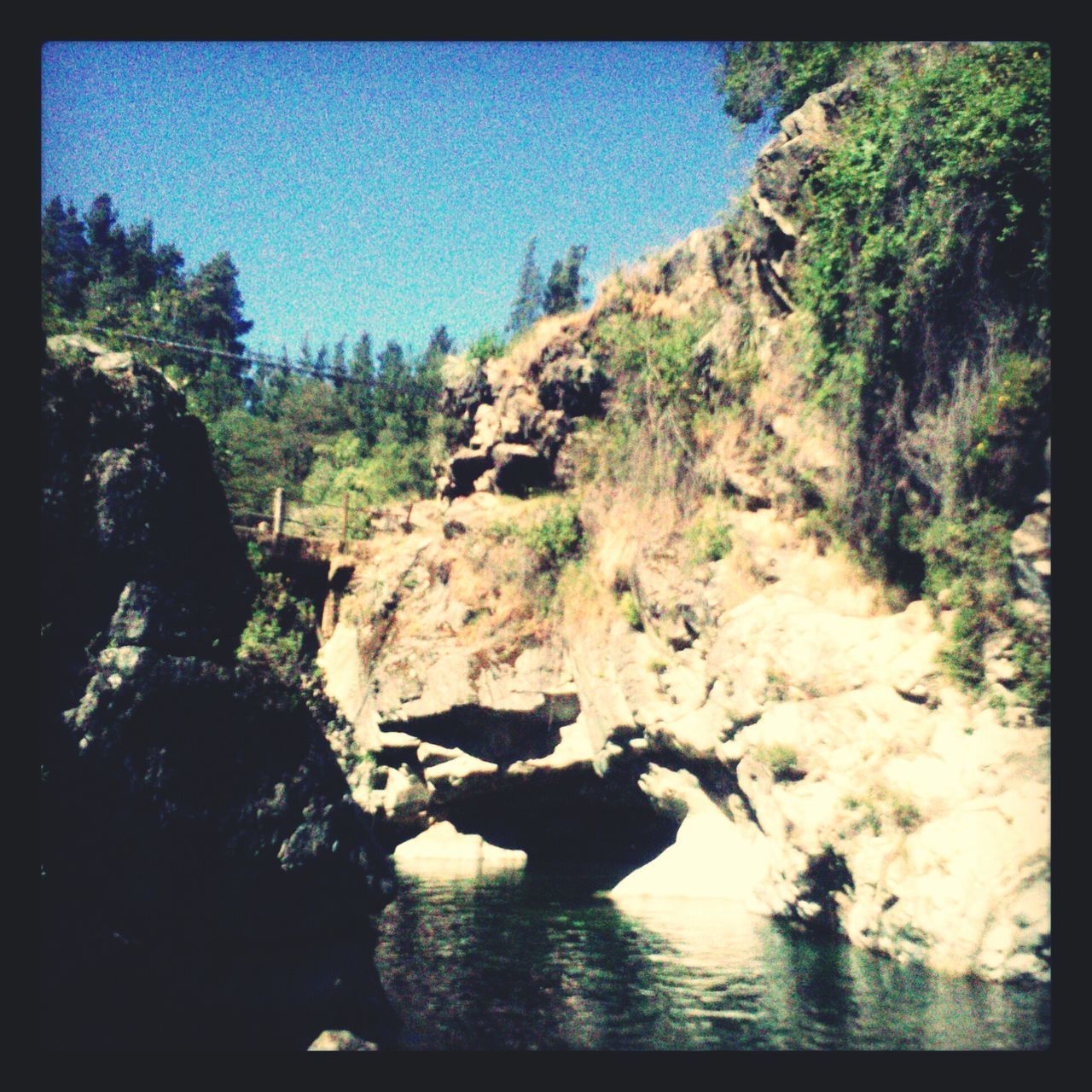 water, tranquil scene, tranquility, scenics, beauty in nature, nature, rock formation, tree, transfer print, clear sky, rock - object, mountain, river, rock, waterfront, auto post production filter, lake, idyllic, stream, cliff