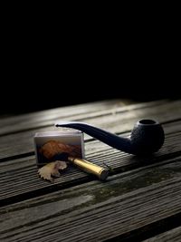 Close-up of smoking pipe with matchstick on table