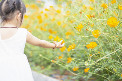 Young woman holding yellow flowers