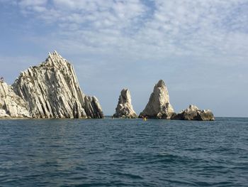 Scenic view of rock formation in sea against sky