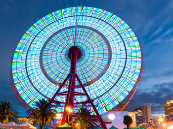 Beautiful ferris wheel spinning long exposure neons in night.