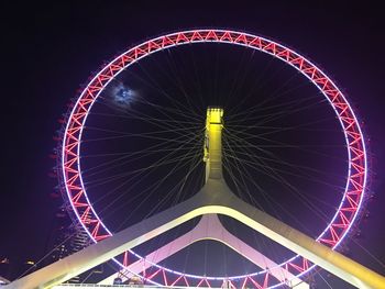 Low angle view of illuminated ferris wheel against sky at night