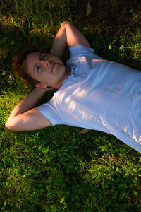 Portrait of young woman lying on field