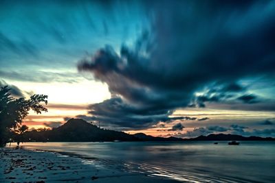 Scenic view of sea against dramatic sky during sunset