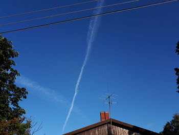 Low angle view of vapor trail against blue sky