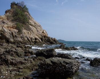 Rock formations by sea against sky