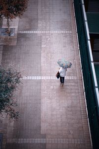 High angle view of man walking on footpath