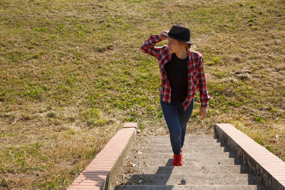 Rear view of woman walking on railroad track