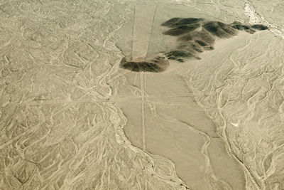 High angle view of tire tracks on sand