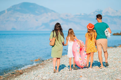 Rear view of women standing on beach