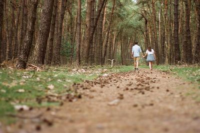 Man standing on tree trunk in forest