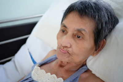 Close-up of senior woman lying on hospital bed
