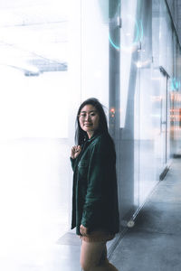 Portrait of woman standing against building