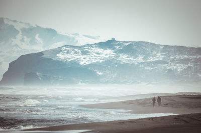 Scenic view of sea and mountains against sky