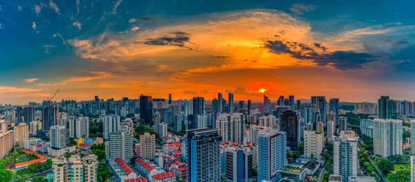 Aerial view of modern buildings against sky during sunset