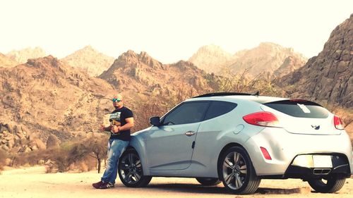 Side view of man standing on road in desert