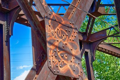 Low angle view of rusty bridge against sky