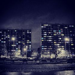 Illuminated buildings against sky at night