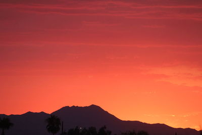 Scenic view of silhouette mountains against sky at sunset