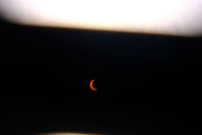 Close-up of orange moon against sky at sunset