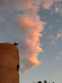 Low angle view of man with arms raised against clear sky