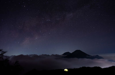 Low angle view of silhouette mountain against sky at night