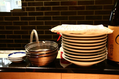 Stack of plates by bowls on kitchen counter