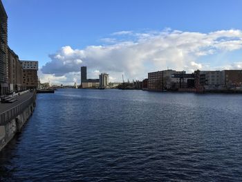 Buildings in city against cloudy sky