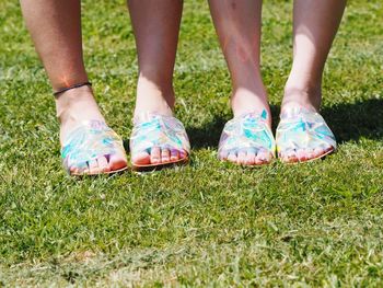 Low section of women standing on field