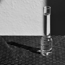 Close-up of water bottle on table against wall