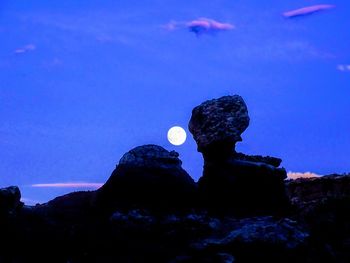 Low angle view of rocks against blue sky at night