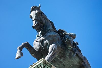 Low angle view of statue against clear blue sky