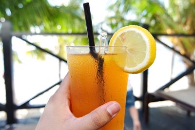 Low section of woman holding orange drink