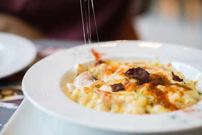 Close-up of macaroni cheese with bacon in the plate.