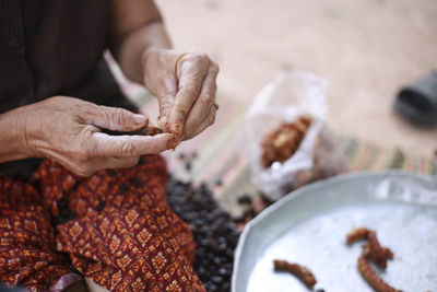 Close-up of hand holding meat on table