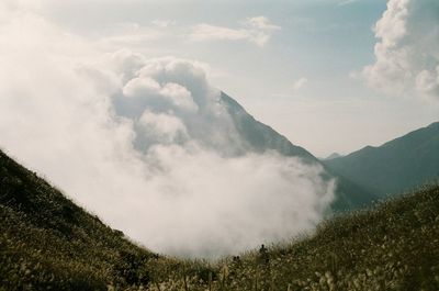 Scenic view of mountains against cloudy sky