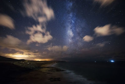 Scenic view of sea against star field at night