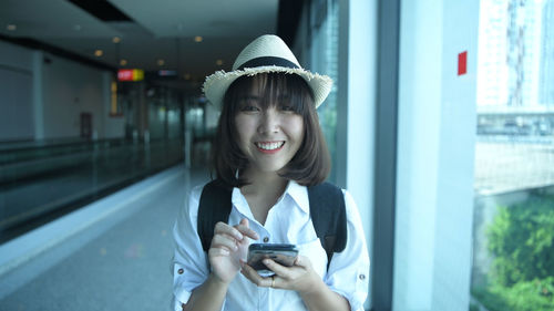 Portrait of smiling young woman using mobile phone