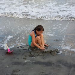 Girl sitting on shore at beach