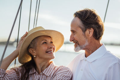 Cheerful couple in boat against sky