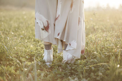 Low section of woman standing on field