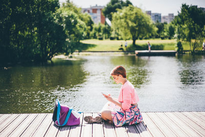 Portrait of woman sitting by lake