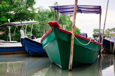 Boats moored on lake against trees